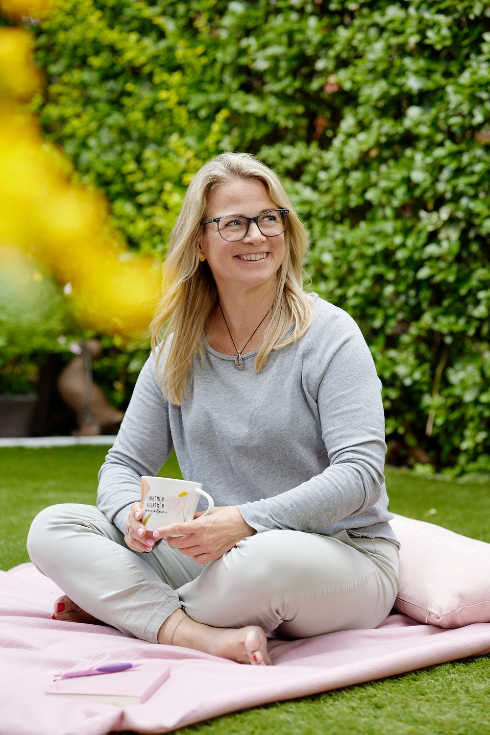 Kirsten Kau macht ein Handherz, während sie zwischen rosa Luftballons steht