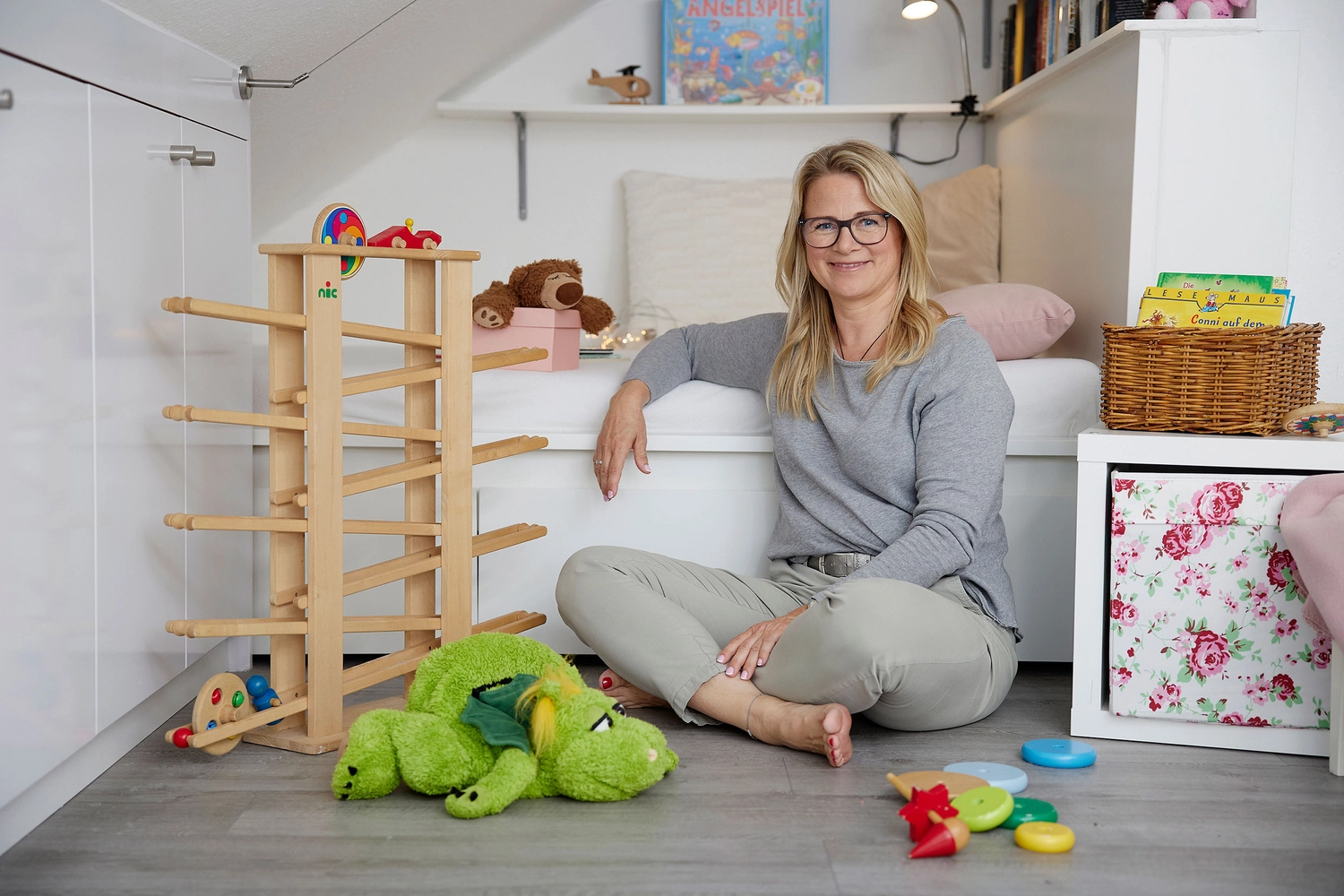 Kirsten macht ein Handherz, das in rosa Luftballons steht
